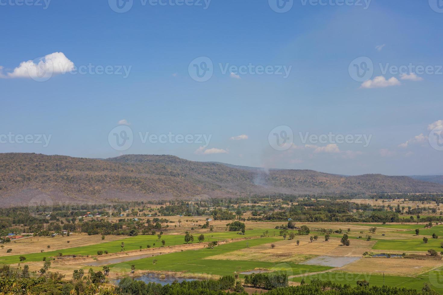 A panoramic view of the hills with villages, trees and rice fields with clouds in the sky. photo