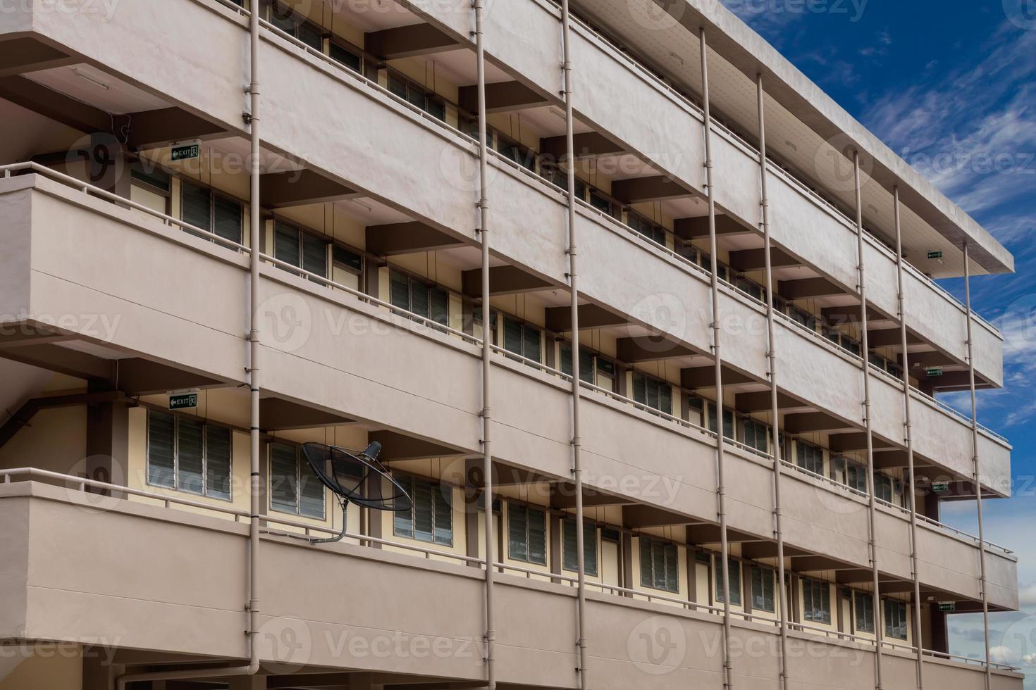 Row of multi-storey brown buildings with sky clouds. photo