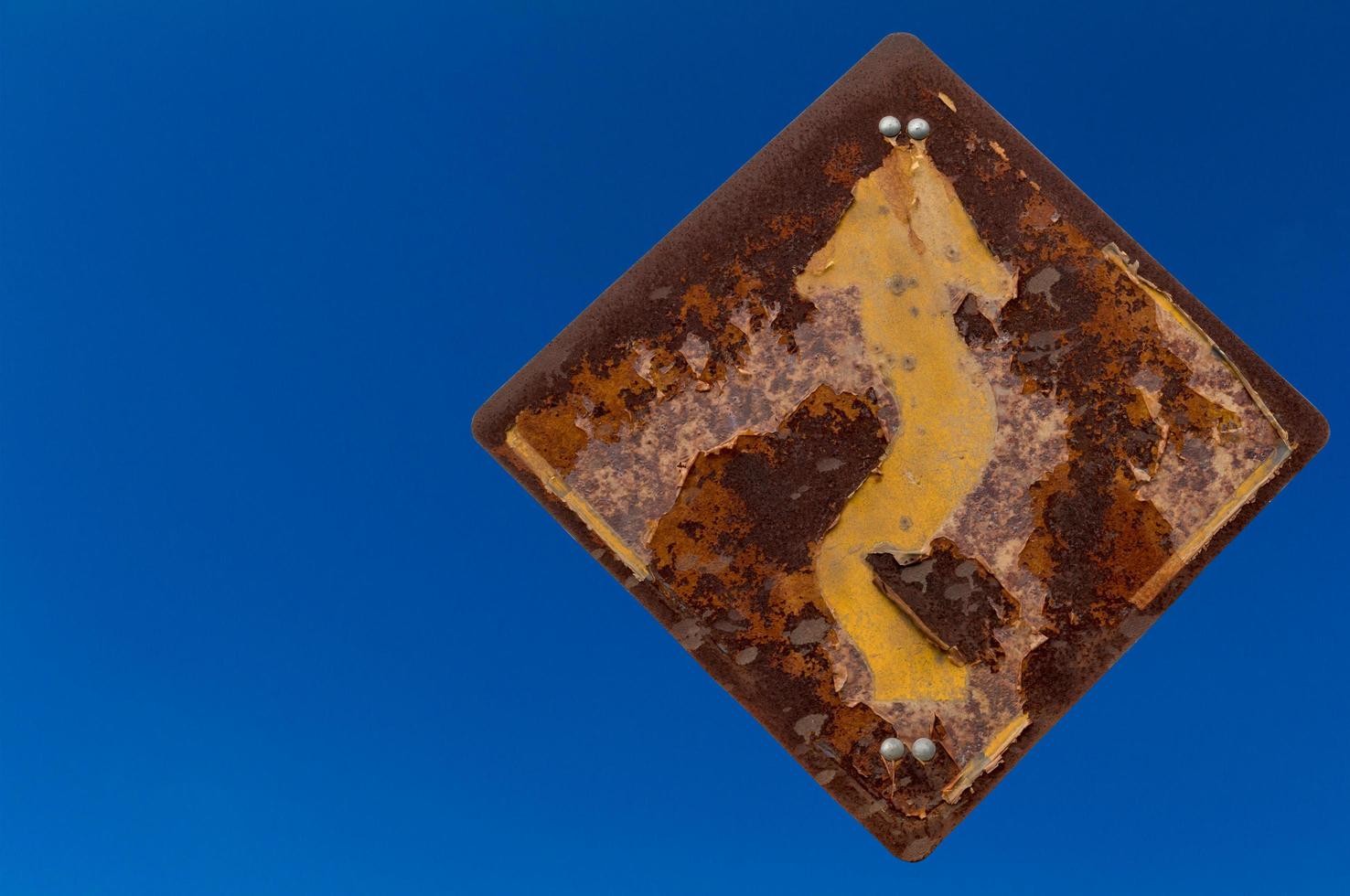 Old rusty signpost bends to the sky. photo