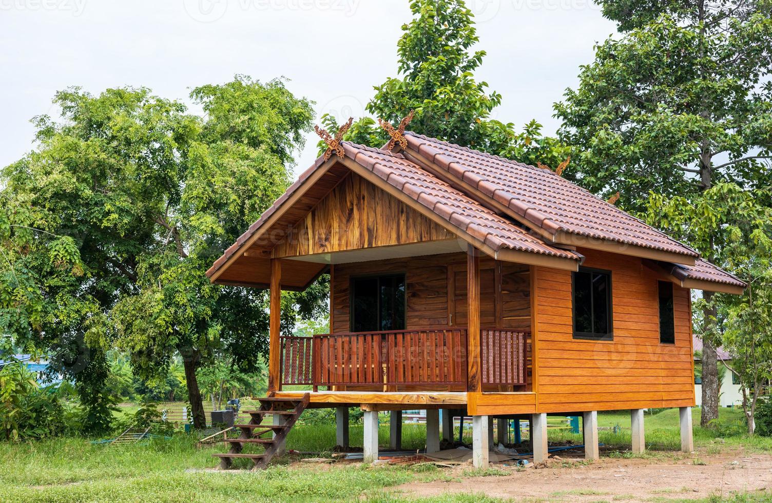 pequeña casa de madera de estilo tailandés, cerca de muchos árboles. foto