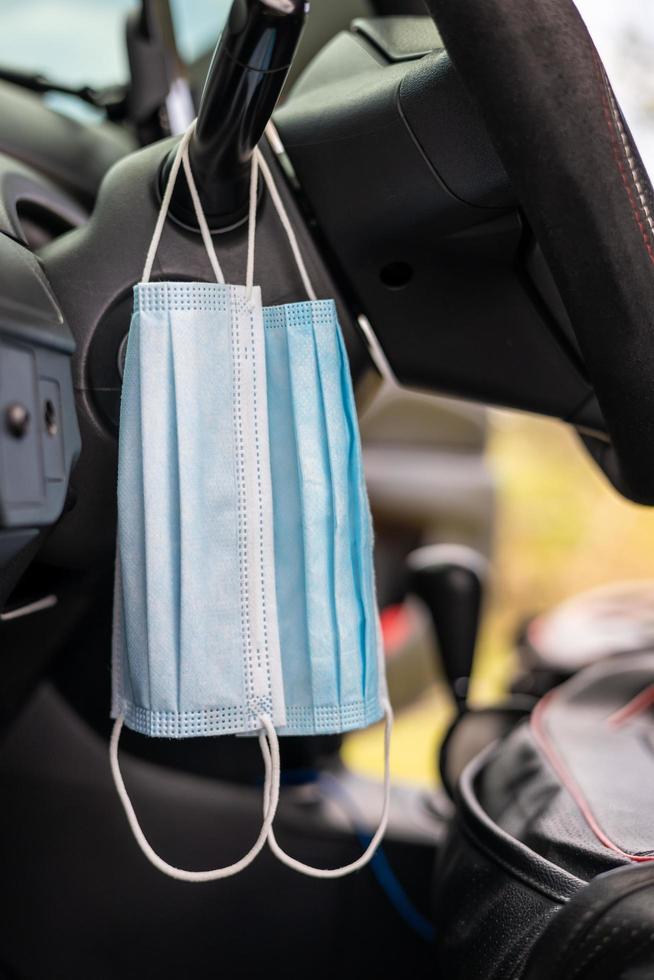 Two pieces of blue face masks hung inside the car. photo