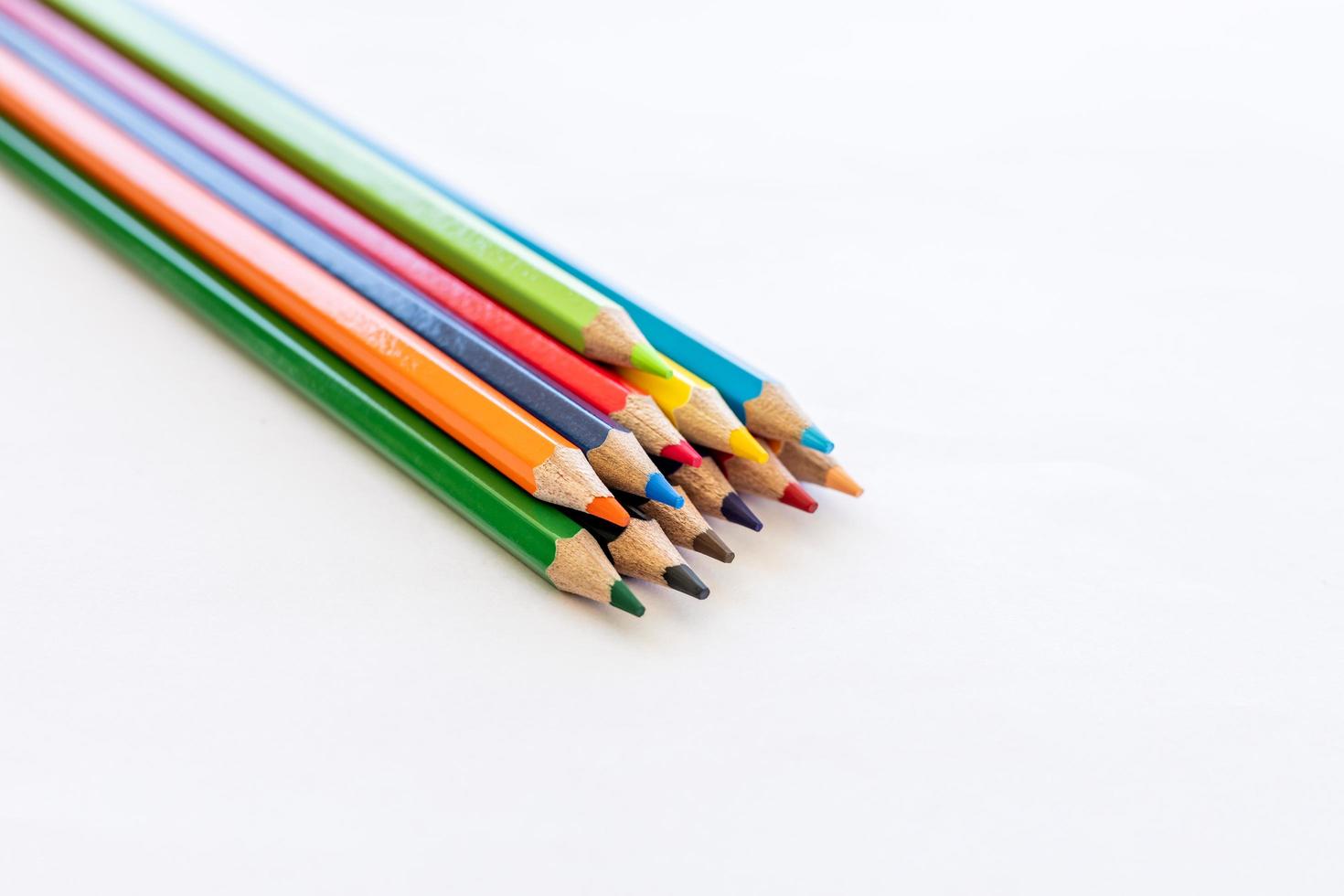 Close-up isolated, colorful pencils stacked on white paper. photo
