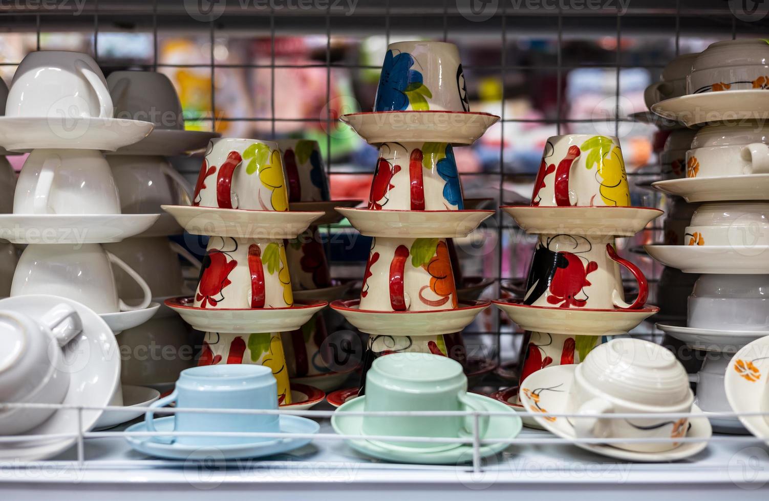 A group of ceramic cups painted in red patterns stacked on top of each other. photo