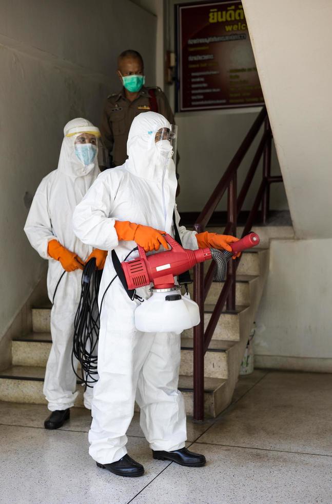 Both men, wearing PPE uniforms, sprayed cleaning the stairs. photo