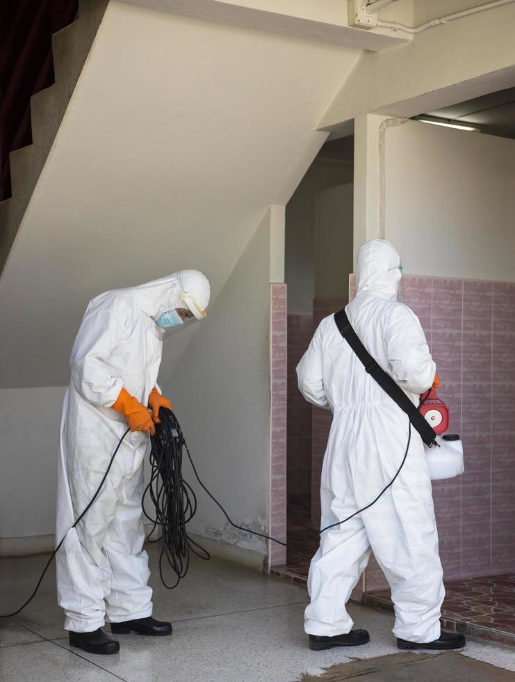 Both, wearing a PPE set, were sprayed to clean the toilet. photo