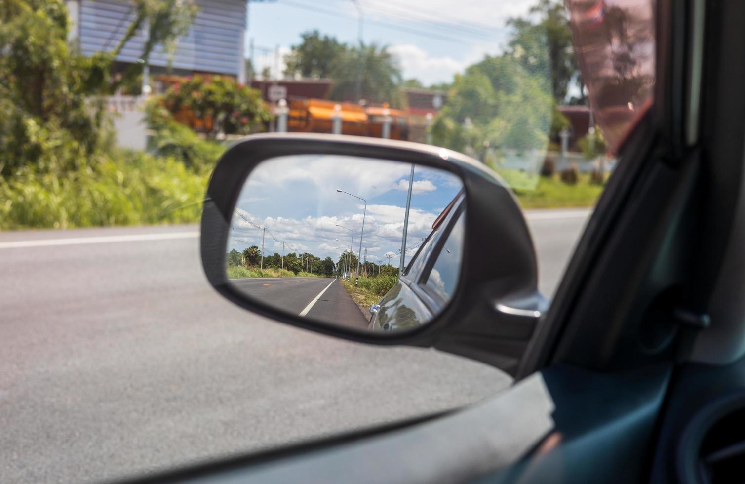 Sky clouds from the side mirrors of the car during daytime in the countryside. photo