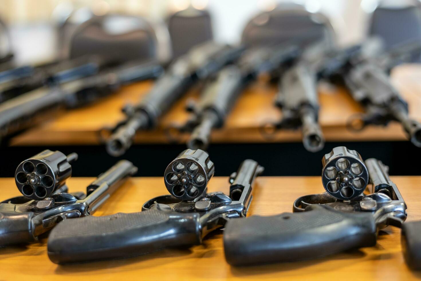 A .38 caliber firearm and a rifle are placed on the table. photo