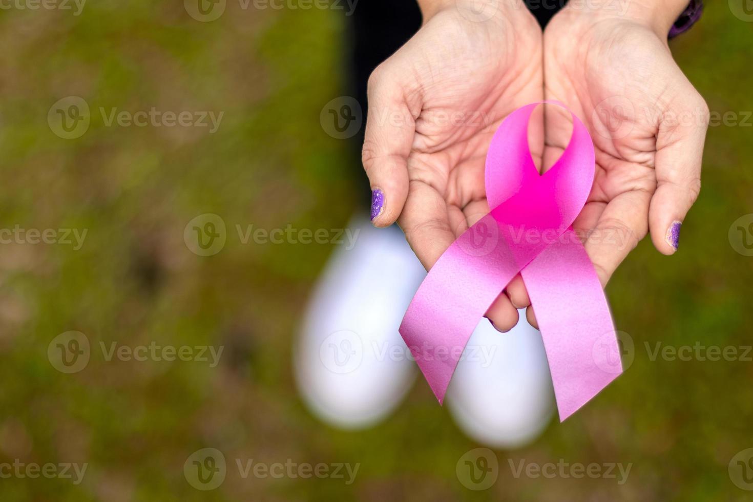 Close-up above the anti-breast cancer symbol on the female hand. photo