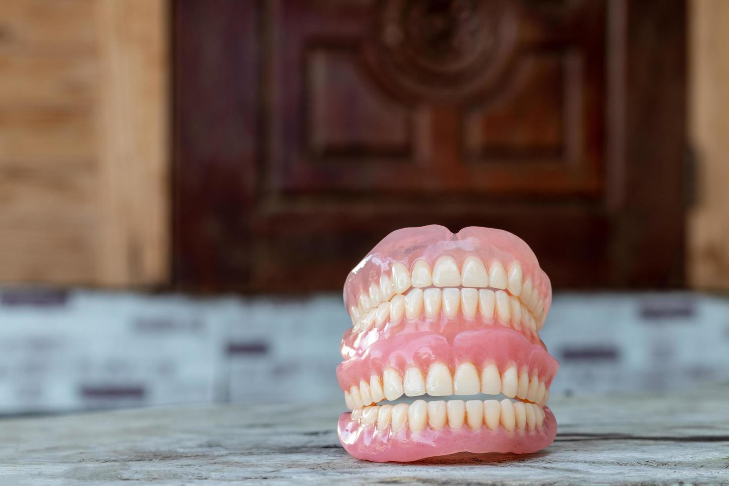 Dentures stacked with wooden doors blur. photo