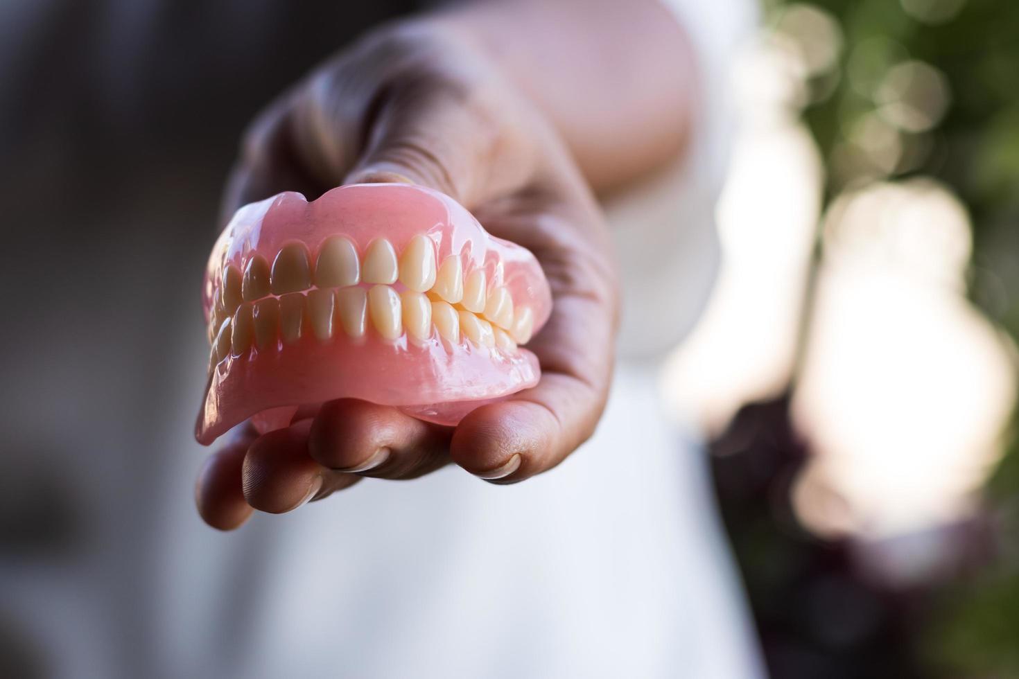 Denture in the hand of elderly women in rural Thailand. photo