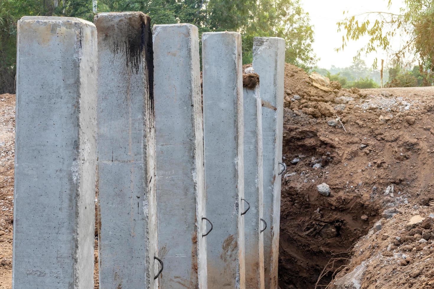 muchos postes de hormigón en el suelo excavado para la construcción. foto