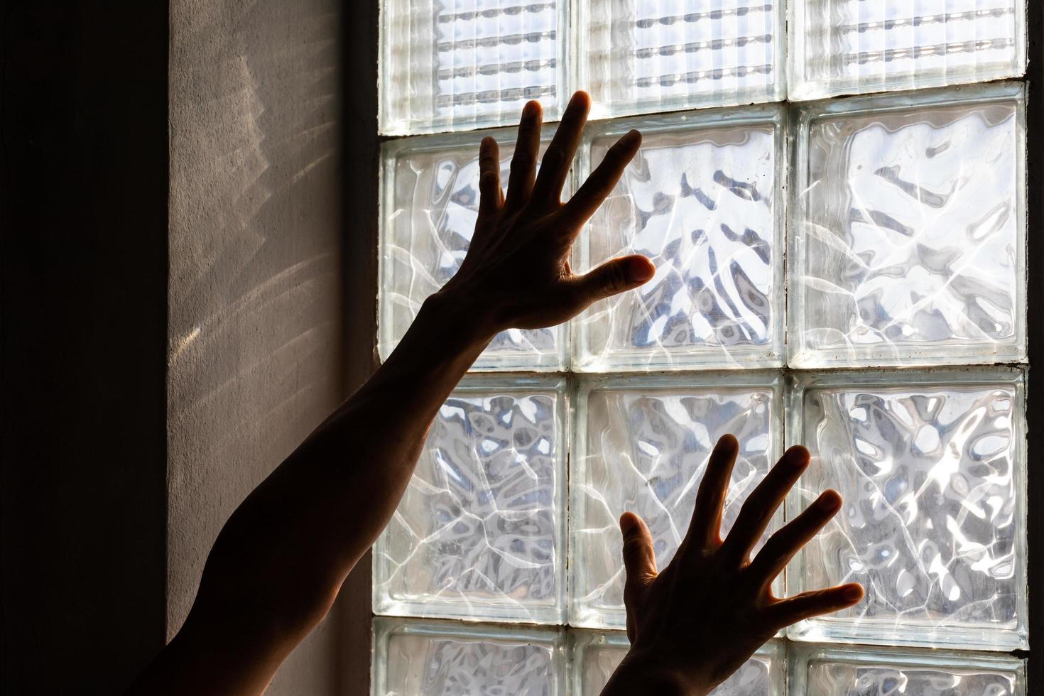 Hands near glass brick wall. photo