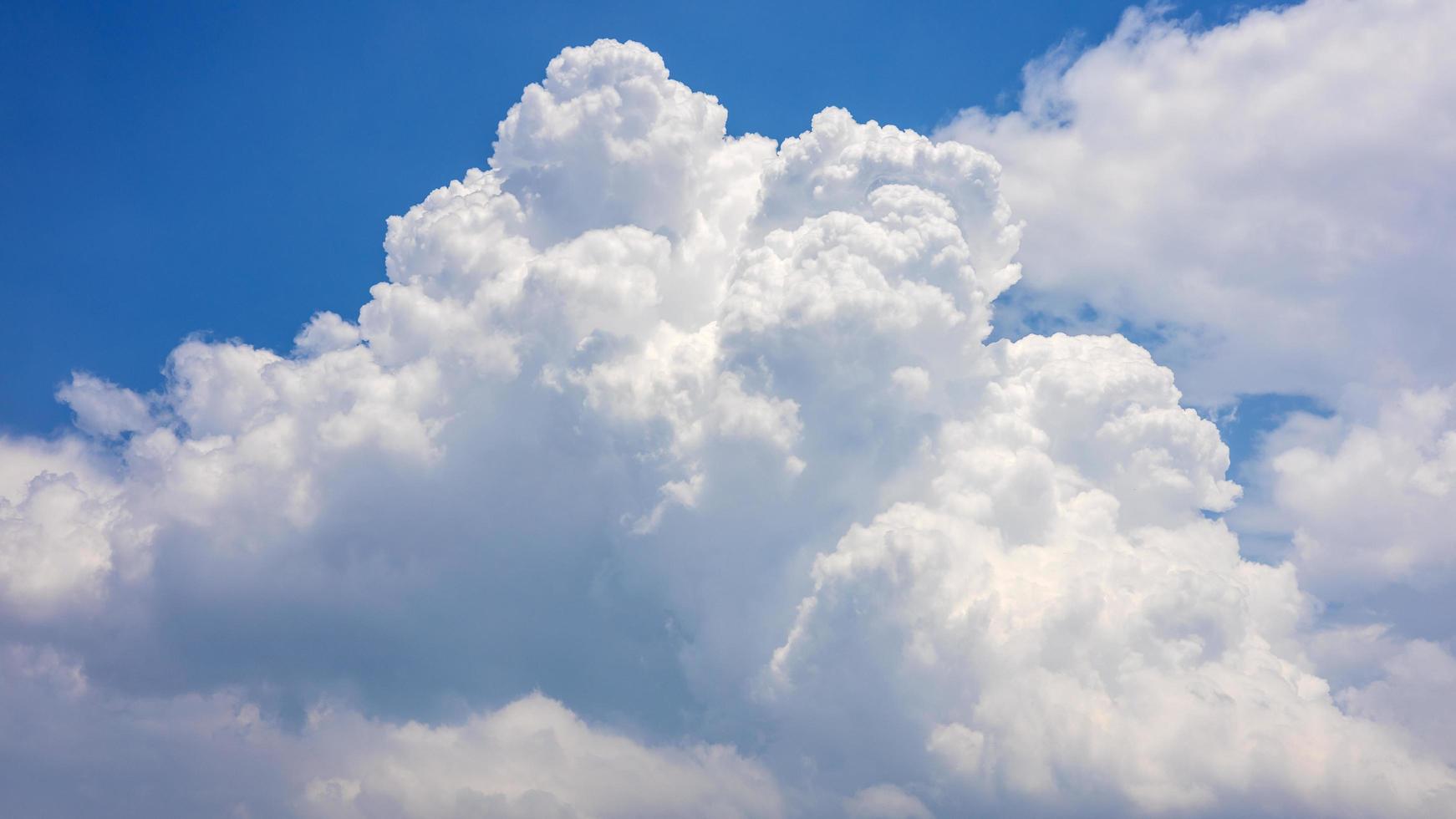 Fluffy clouds float in the sky during the day. photo