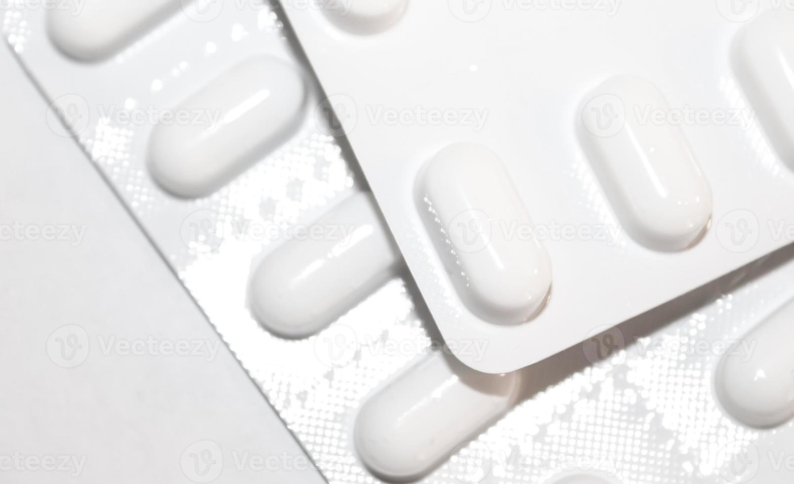 concepto de farmacia farmacia. paquetes de pastillas blancas envasadas en ampollas con espacio de copia aislado en un fondo blanco. centrarse en primer plano, bokeh suave. foto