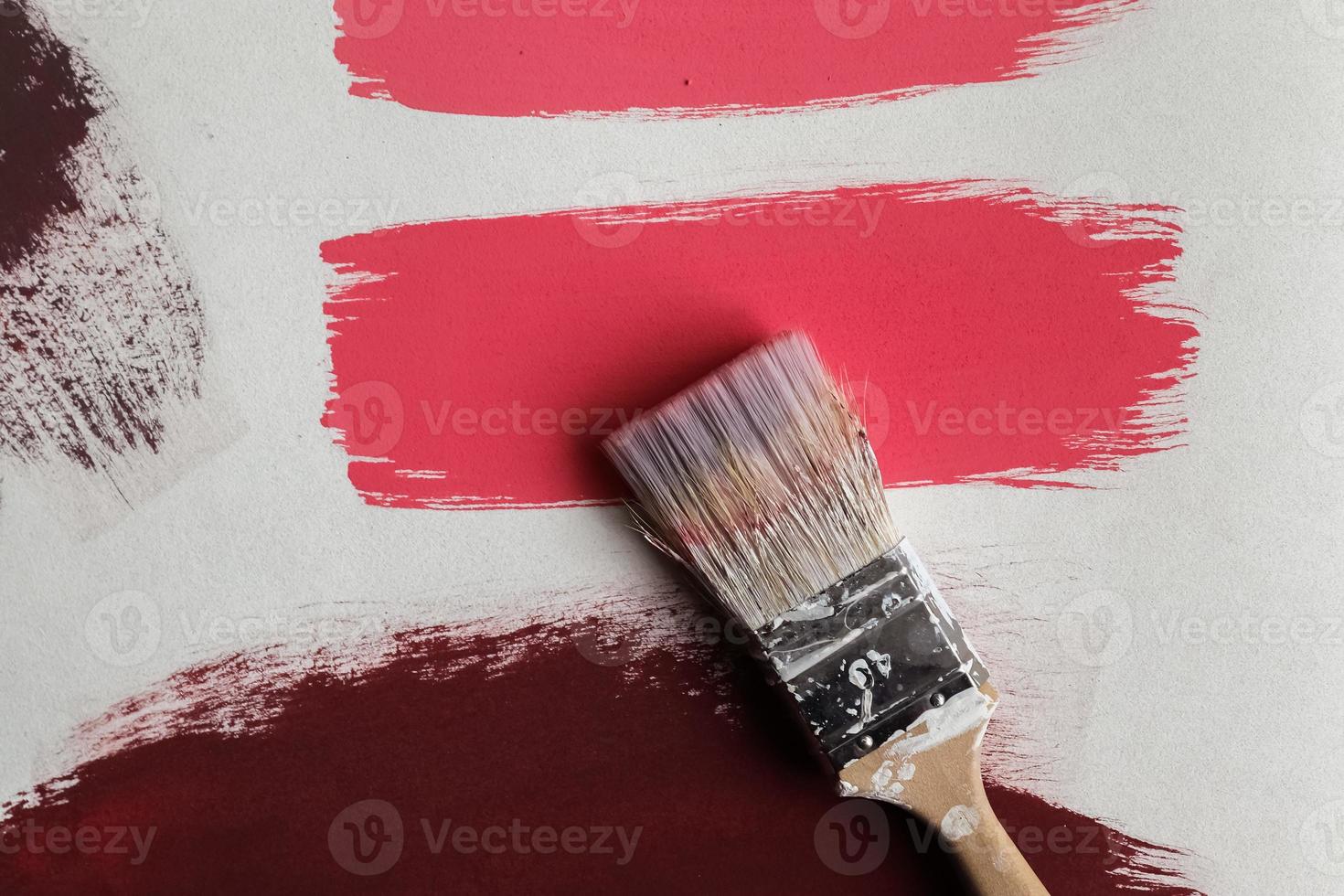 Concept of a paintbrush on a piece of paper with brush strokes in red and brown photo