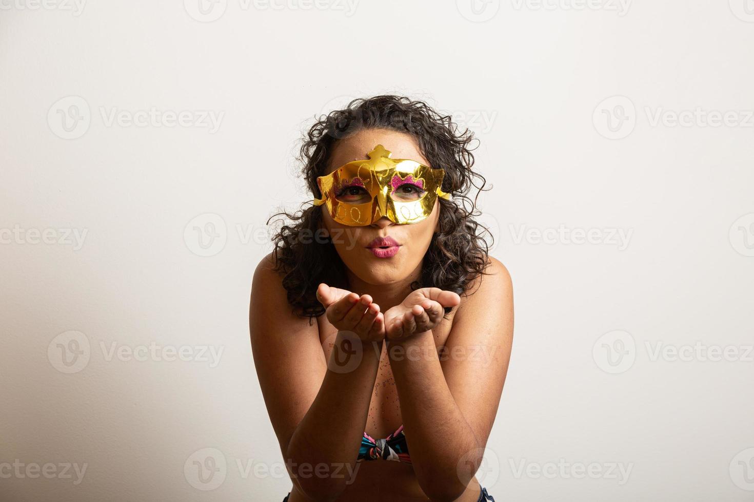 Lets party Girl blowing confetti against white bakground. Happy young woman having fun at carnival. Mardi gras holiday concept. photo