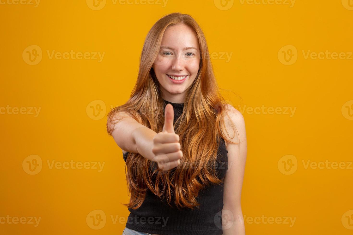 Close up photo of pretty foxy lady raising thumb up expressing agreement wear checkered casual shirt isolated yellow color background. Redhead girl. Okay.