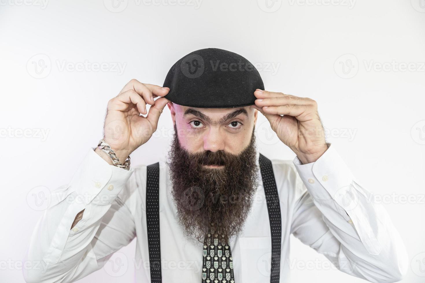 Bearded man looking at the camera. Concept of masculinity and care with the beard. Pointing with finger, approving or indicating. photo