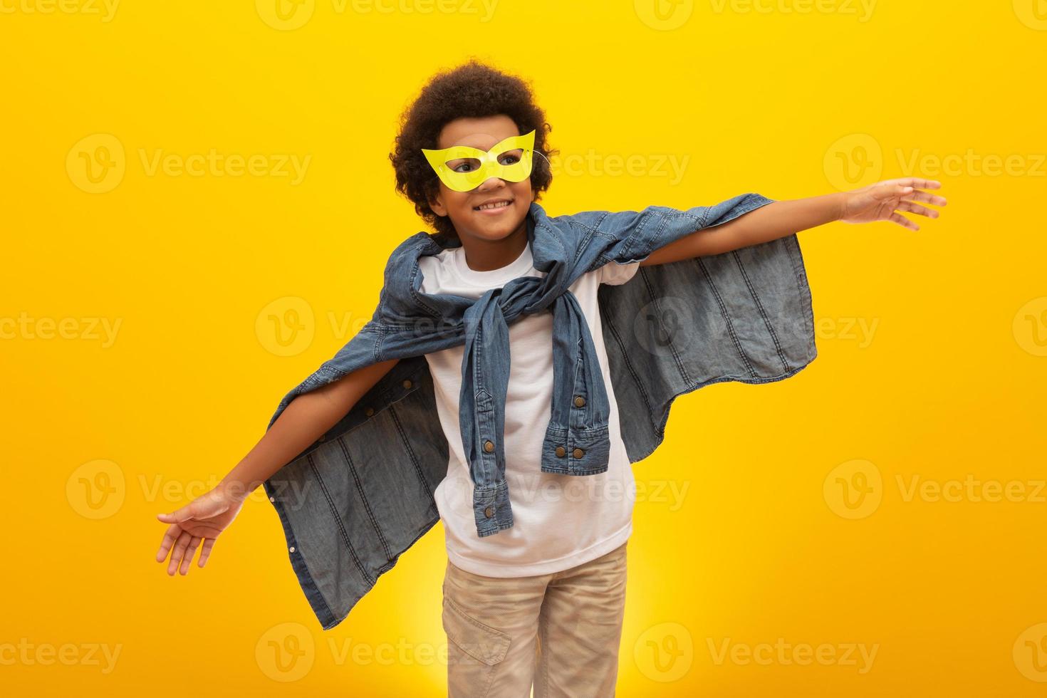 Portrait of a young, mixed race boy dressed as a superhero. Black baby in super hero costume. The winner and success concept. photo