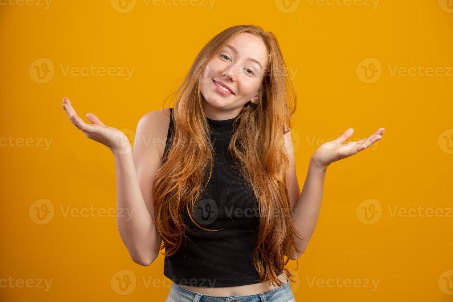 Overwhelmed excited smiling, happy redhead girl celebrating amazing news, achieve victory, winning competition, triumphing as become champion, gain goal or unexpected lucky event happened. On yellow. photo