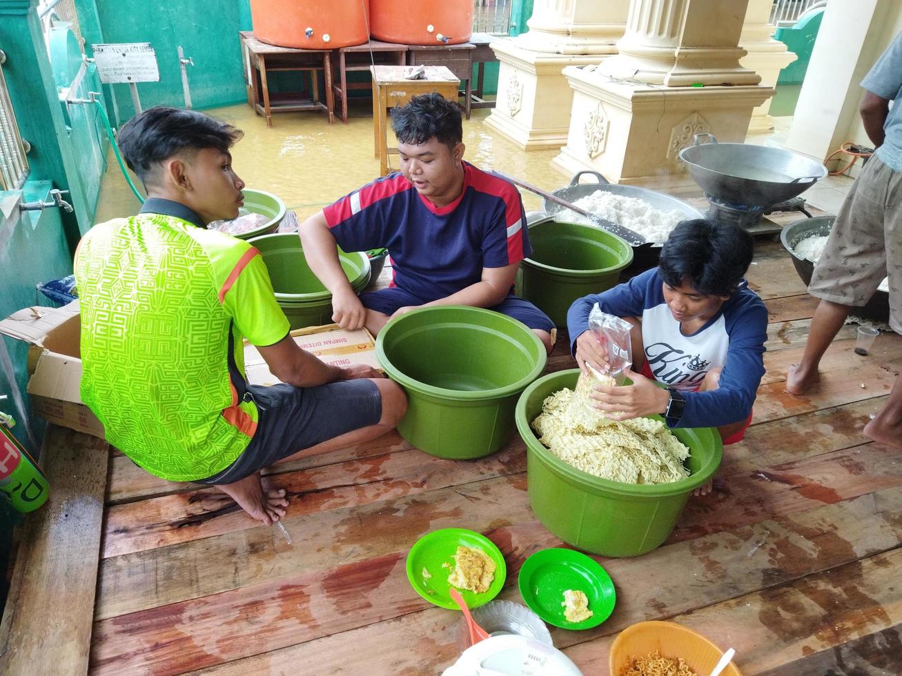 Kasongan, Indonesia. 2022. Three men are getting ready to cook noodles photo