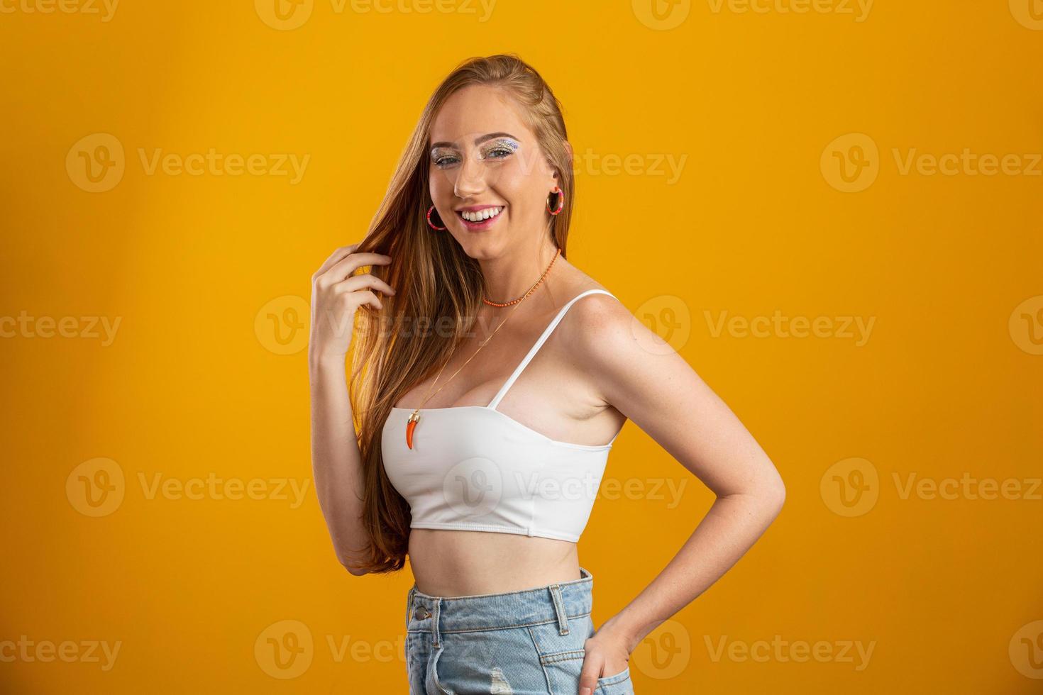 Portrait of beautiful cheerful redhead blonde girl smiling laughing looking at camera over yellow background. photo