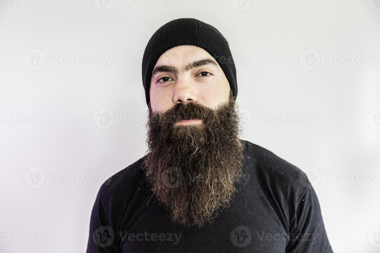 Bearded man looking at the camera. Concept of masculinity and care with the beard. Pointing with finger, approving or indicating. photo