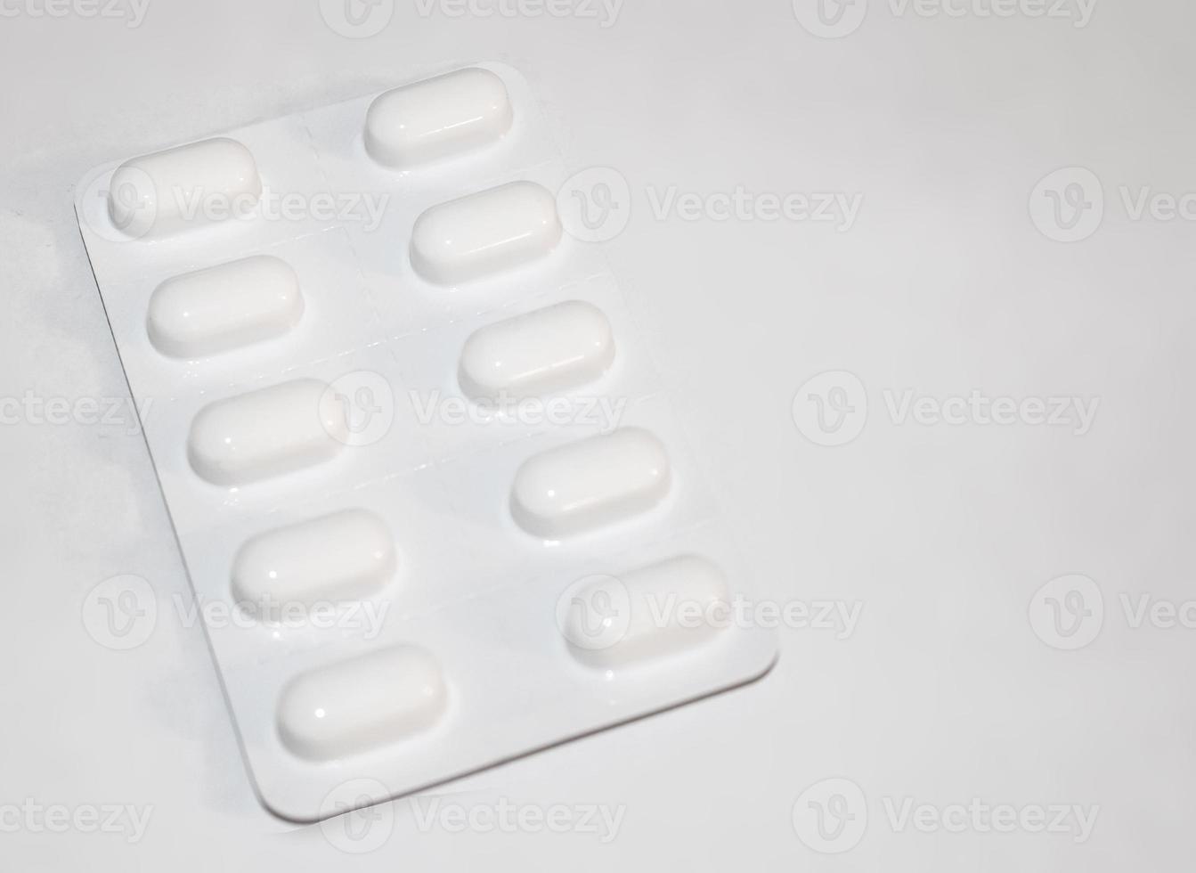 concepto de farmacia farmacia. paquetes de pastillas blancas envasadas en ampollas con espacio de copia aislado en un fondo blanco. centrarse en primer plano, bokeh suave. foto