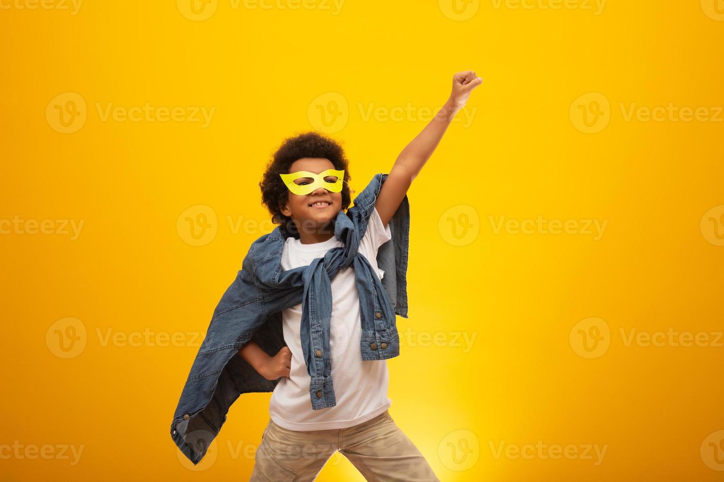 Portrait of a young, mixed race boy dressed as a superhero. Black baby in super hero costume. The winner and success concept. photo