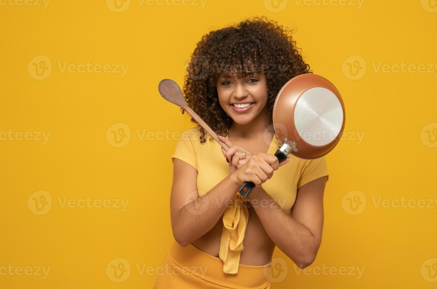 Cooking utensils. Cooking woman in kitchen with frying pan and wooden  spoon. Housewife dancing. Stock Photo