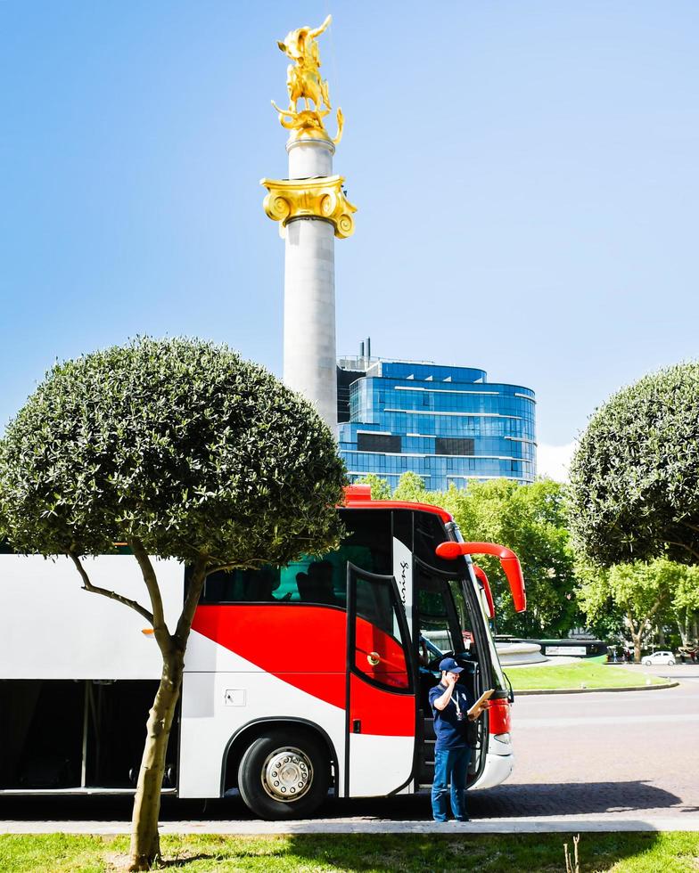 tbilisi, georgia, 2022 - guía del operador turístico de pie junto al autobús de recogida foto