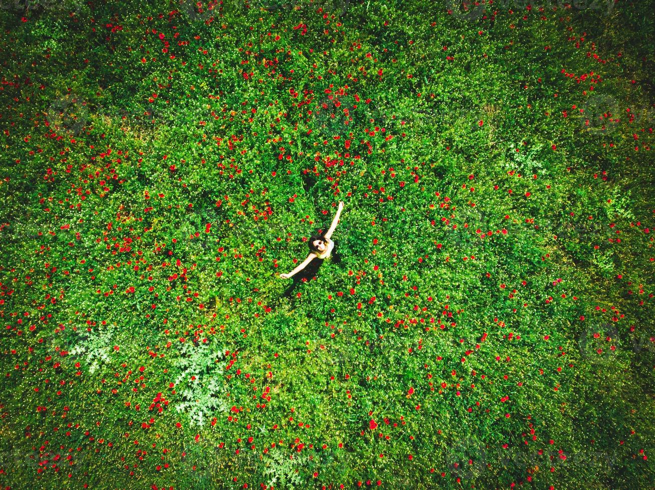 Aerial top down view young caucasian woman with spreaded hands enjoy freedom and spring season outdoors in nature. Carefree life and life excitement photo