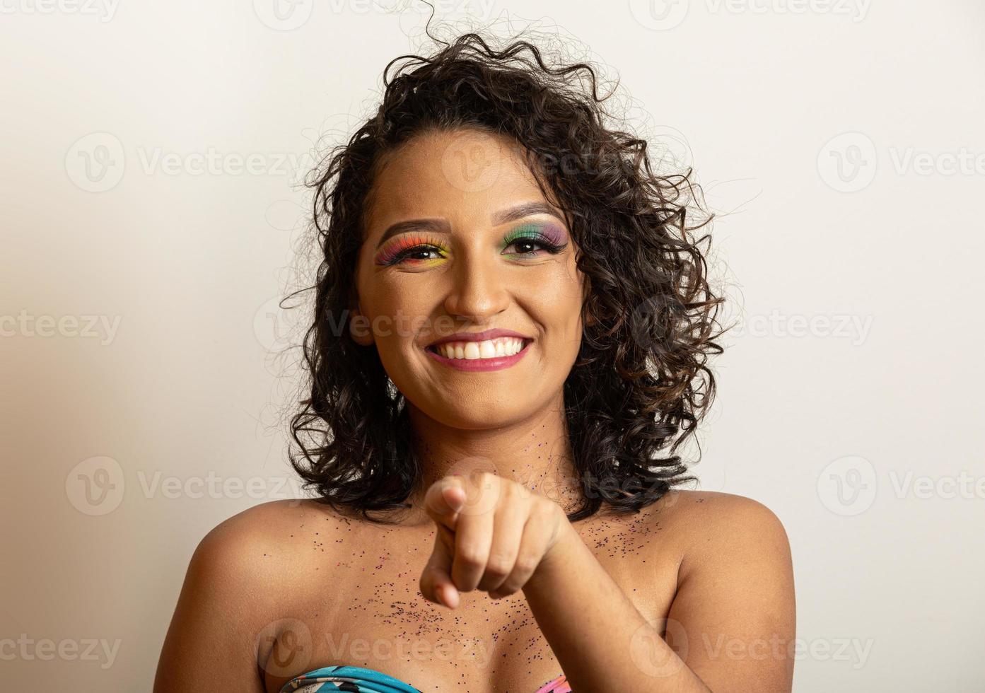 Holiday sale. Happy girl in carnival makeup pointing index fingers at something. Smiling and pointing white background. Pointing gesture. Pointing and promoting. Advert here, copy space. photo