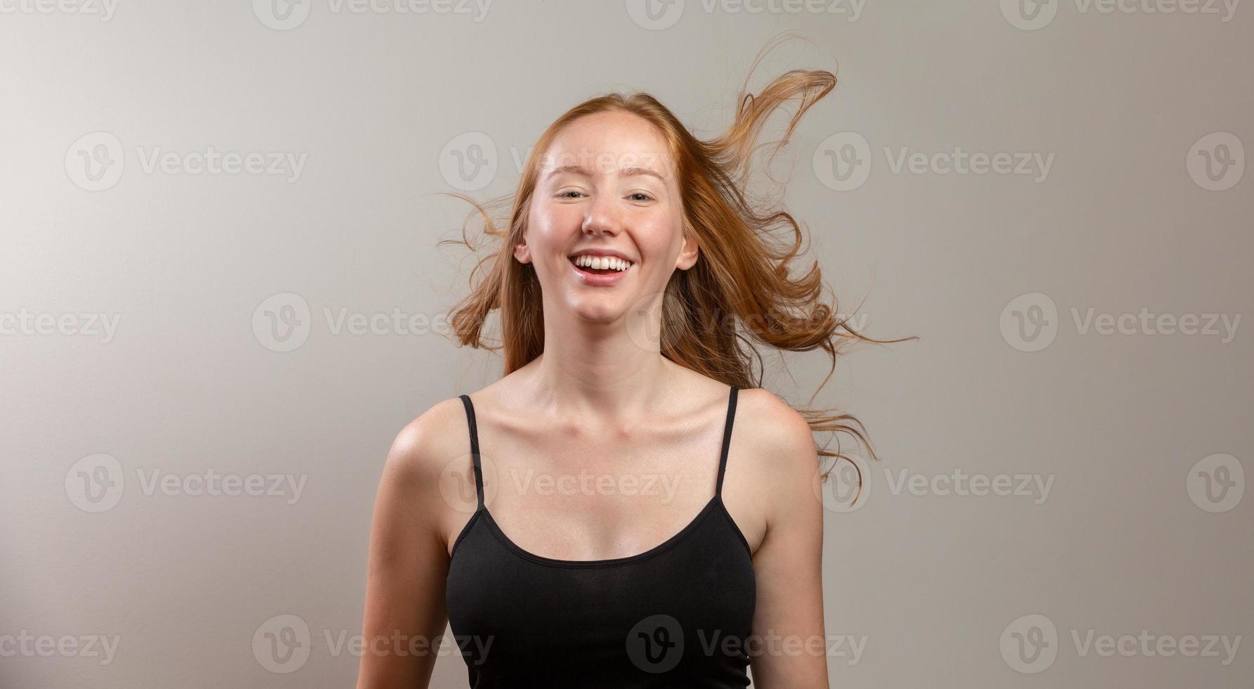 Portrait of beautiful cheerful redhead girl smiling laughing looking at camera over white background. photo