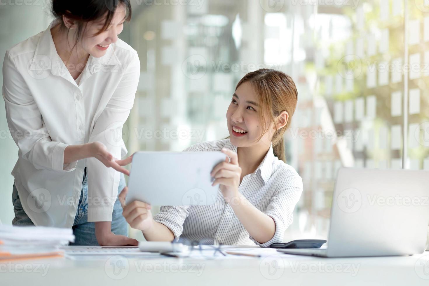 Young Asian businesswoman work together to analysis from work at the office. photo