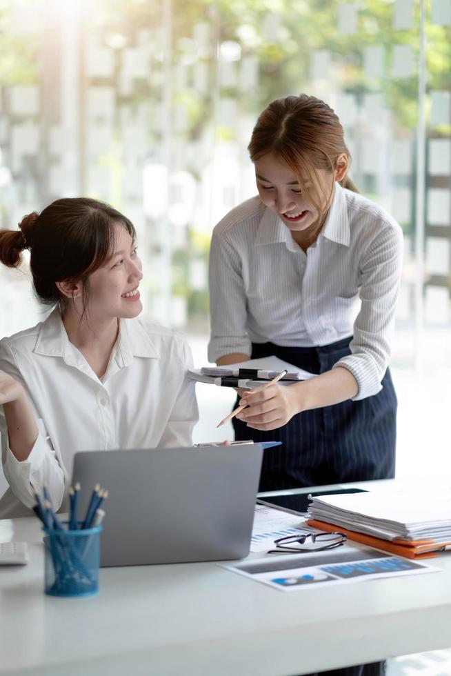 Two Young Asian businesswoman discuss with new startup project Idea presentation, analyze planning and financial statistics and investment market at office. photo