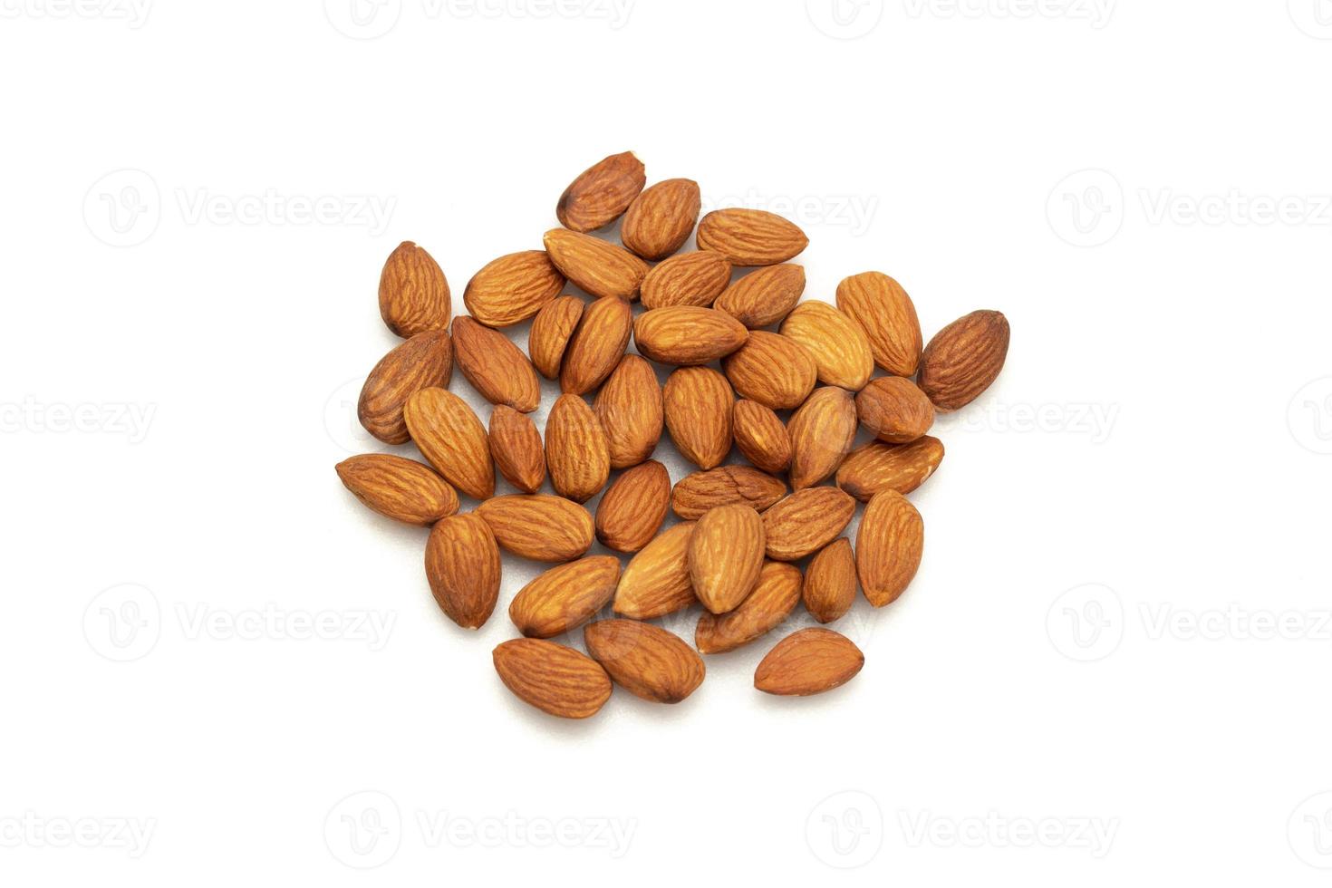 Almonds are placed on the wooden floor at the center of the image, copy space. photo