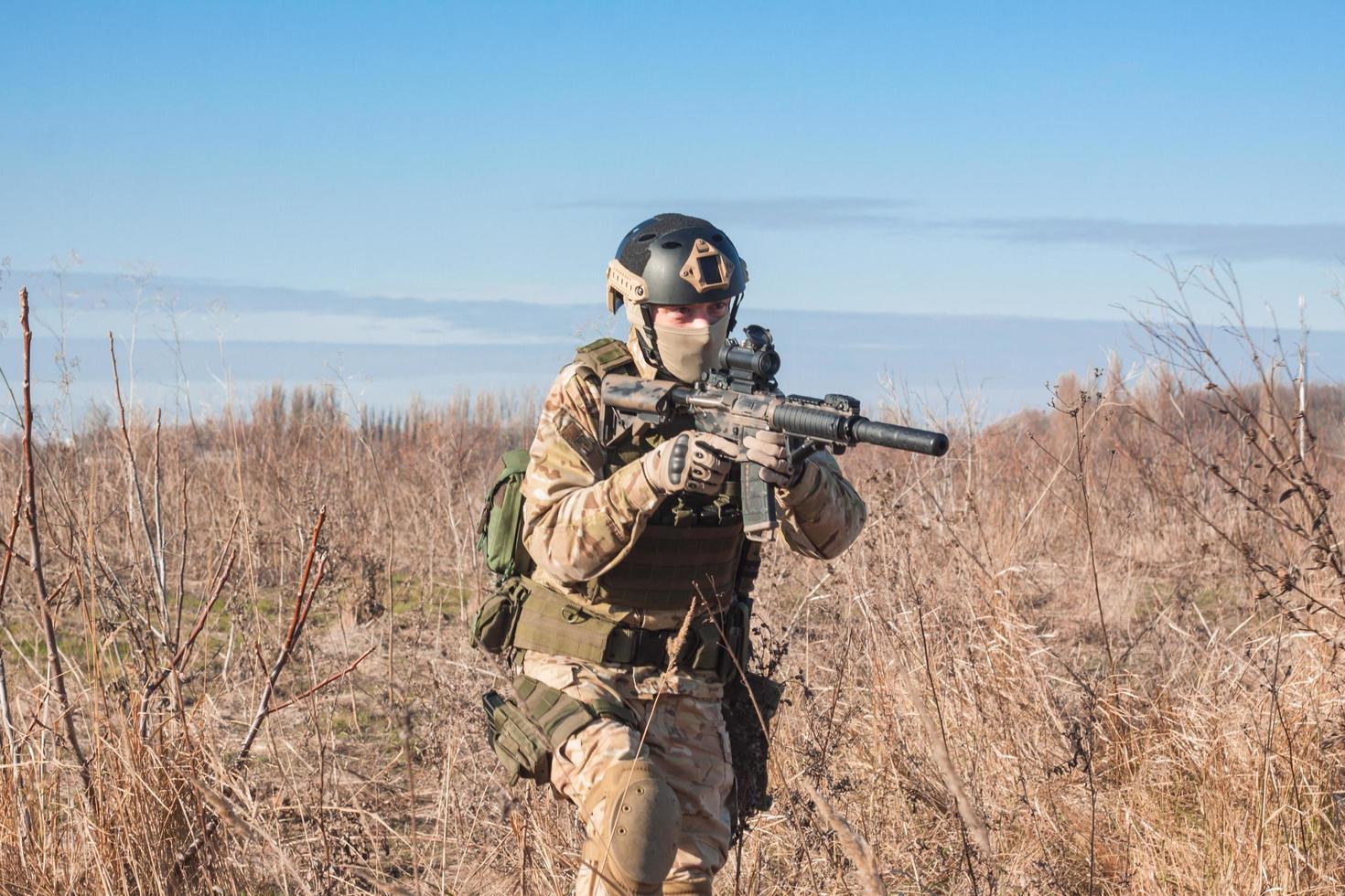 Airsoft Soldiers in posing with rifle in fields photo