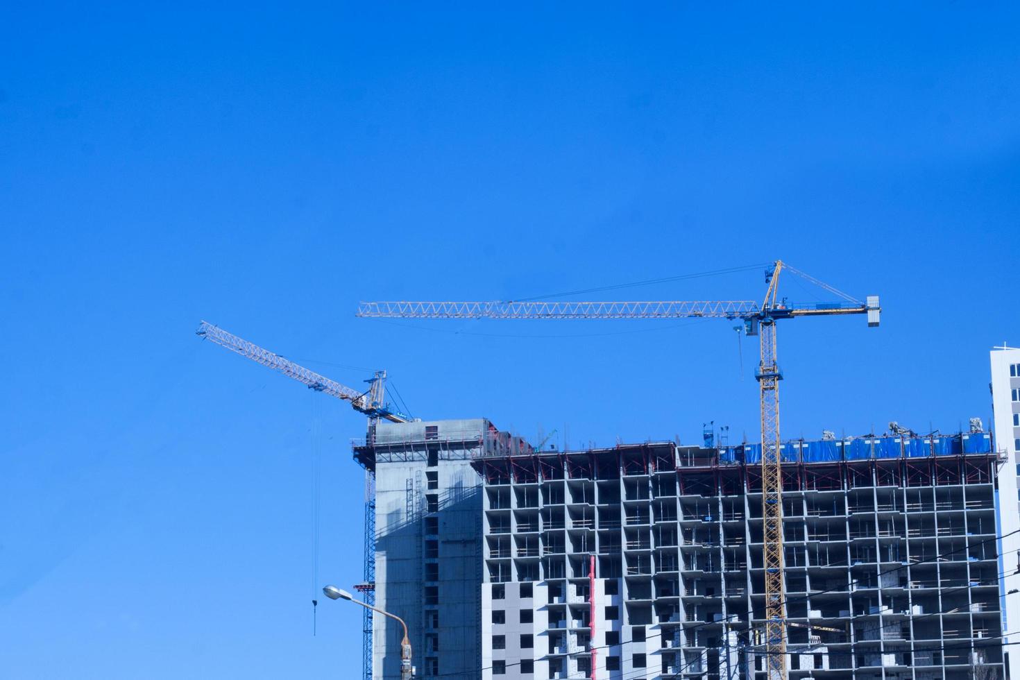 Concrete building in progress with cranes photo