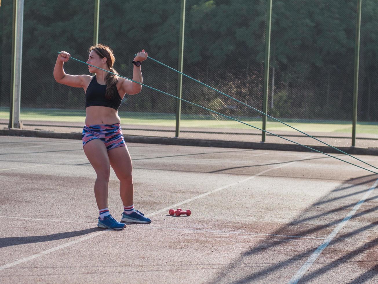 joven mujer fuerte entrenando al aire libre en verano, atleta profesional femenina hace ejercicios en el parque foto