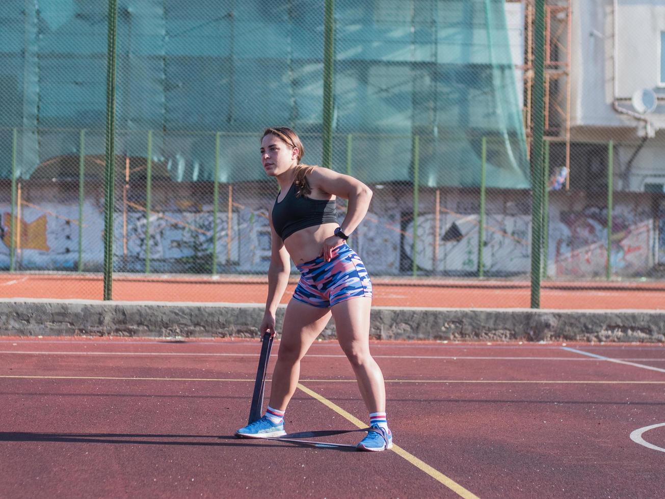 joven mujer fuerte entrenando al aire libre en verano, atleta profesional femenina hace ejercicios en el parque foto