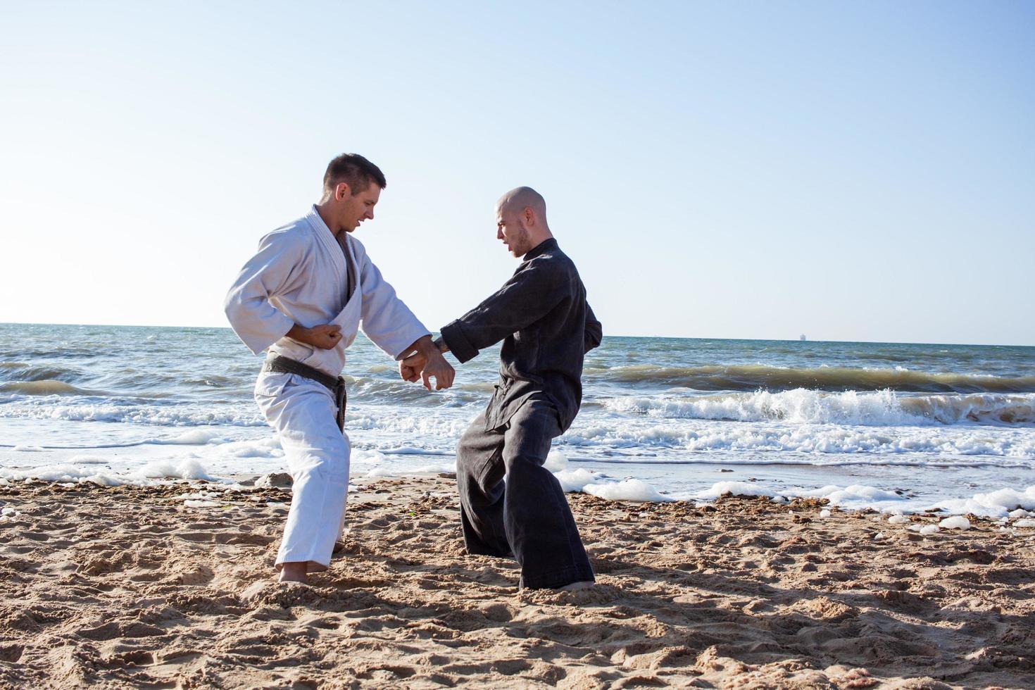 los luchadores de karate están peleando en el ring de boxeo de la playa por la mañana foto