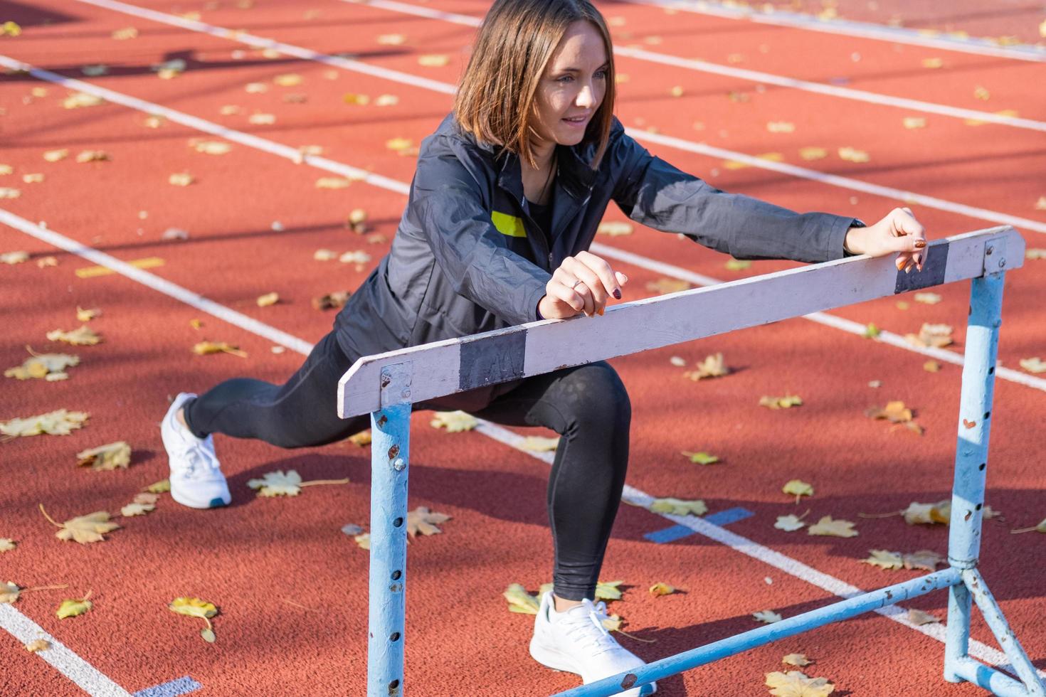 Young female runner training in summer day outdoors on the studium photo