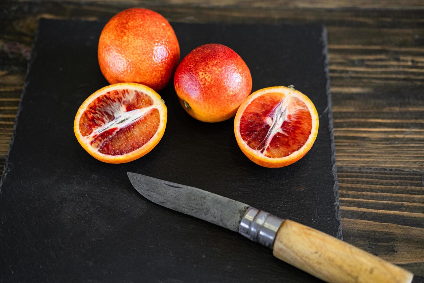 sliced sicilian or bloody oranges on a black slate background photo