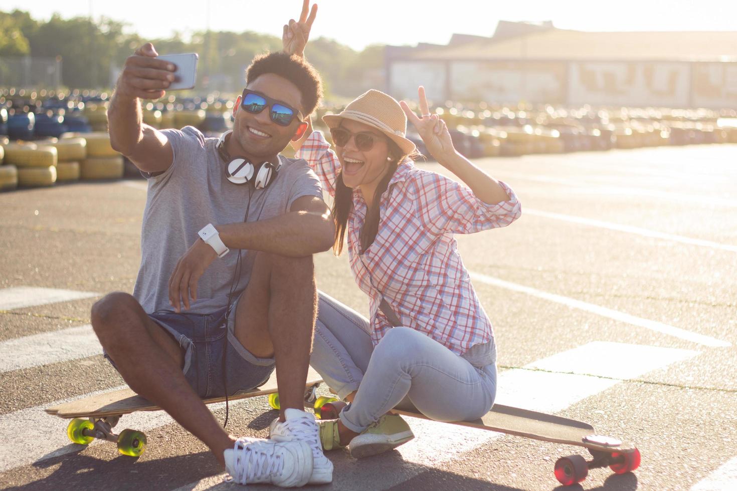 Happy young couple riding skateboard during sunrise photo