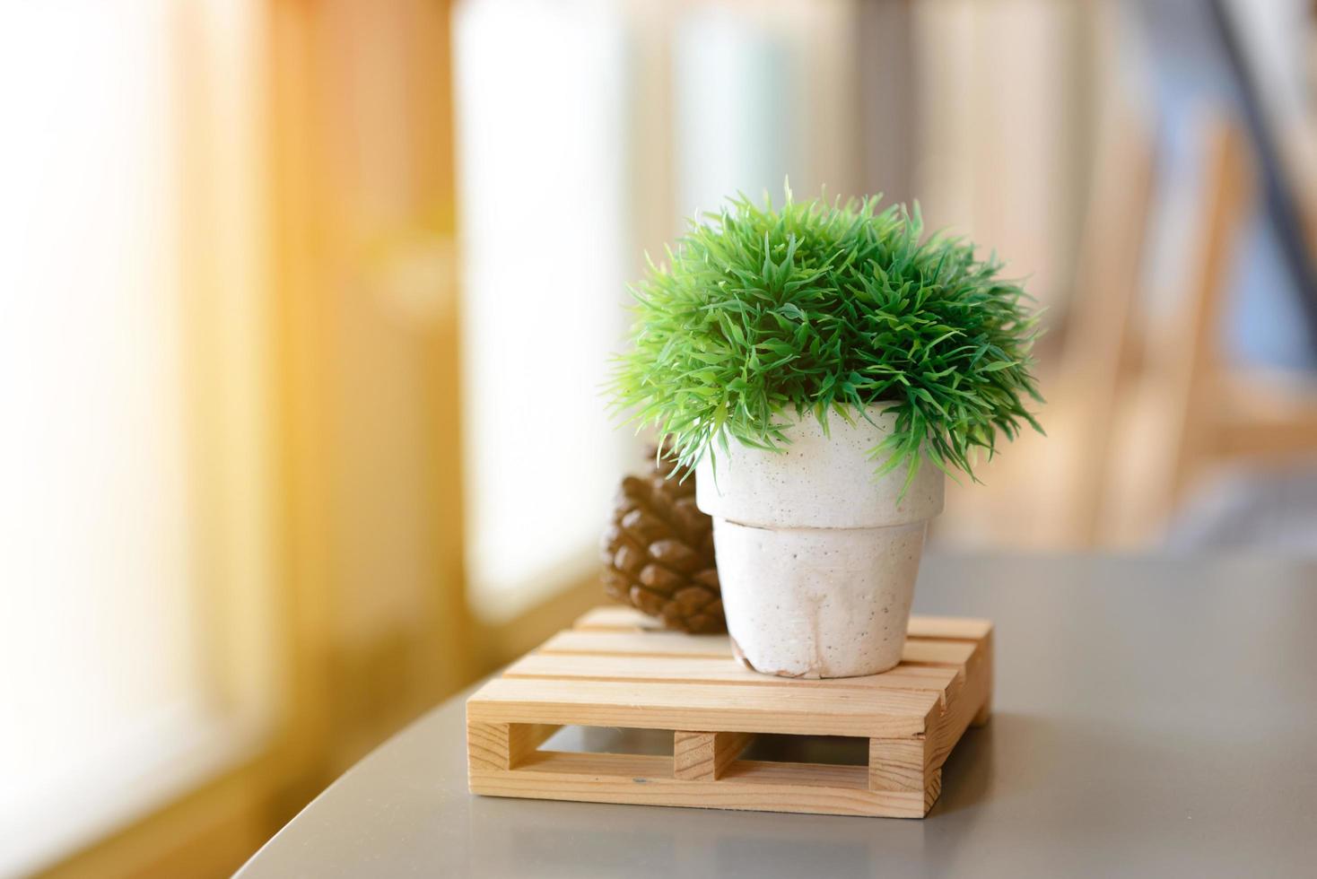 pequeños árboles artificiales o césped artificial en un jarrón sobre una mesa con espacio para copiar foto