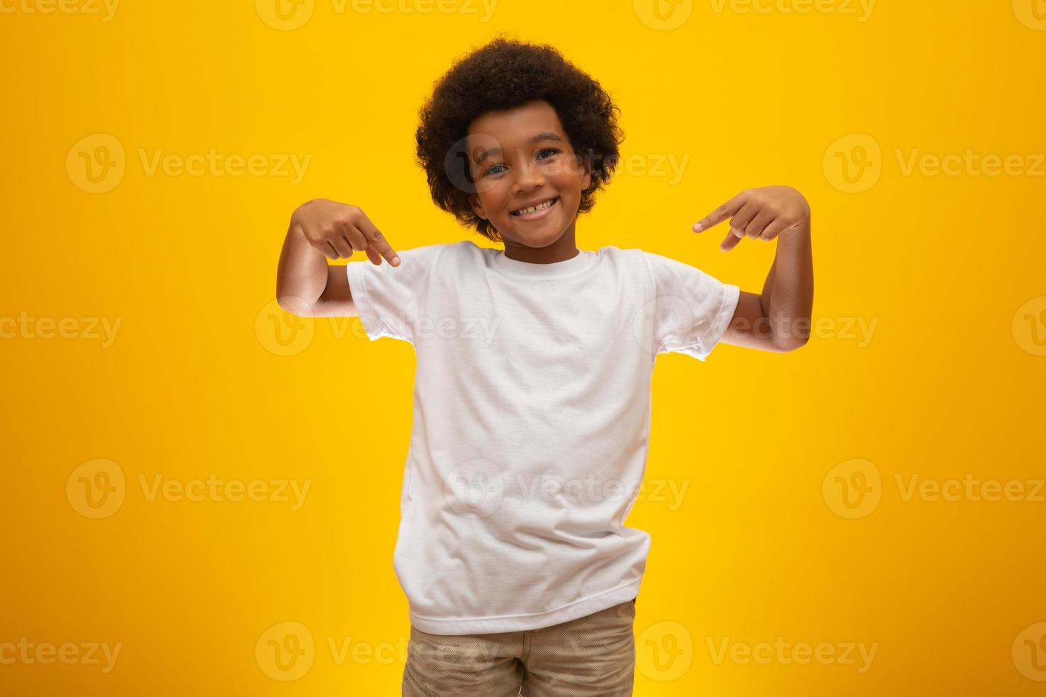 African American boy with black power hair on yellow background. Smiling black kid with a black power hair. Black boy with a black power hair. African descent. photo