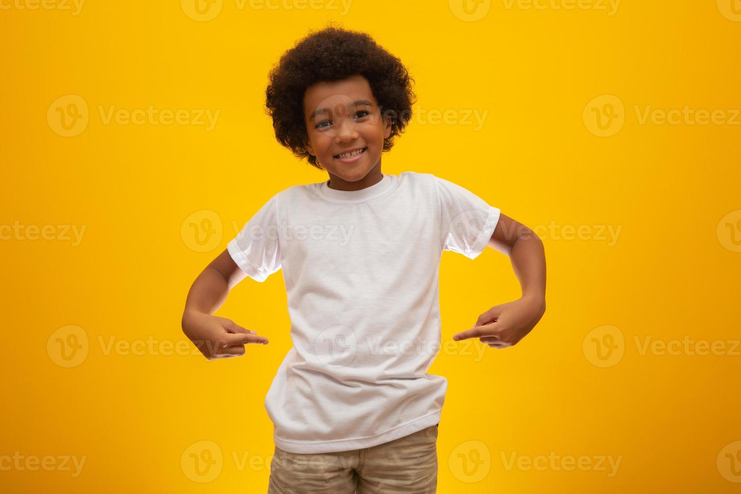 African American boy with black power hair on yellow background. Smiling black kid with a black power hair. Black boy with a black power hair. African descent. photo