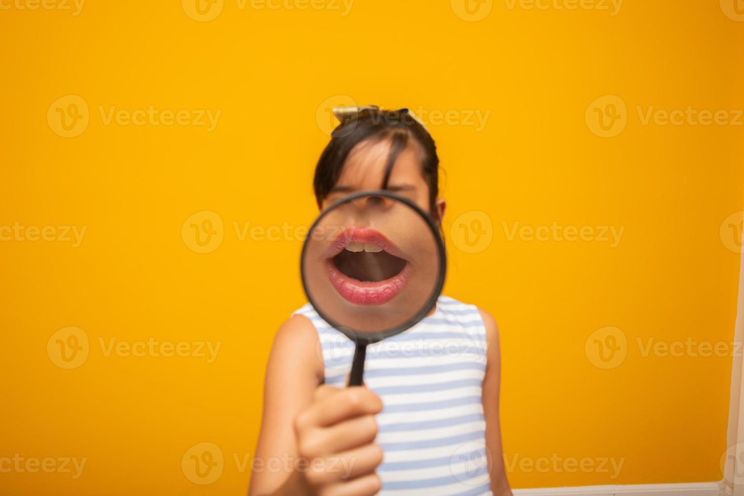 retrato de niño asiático feliz con lupa. foto