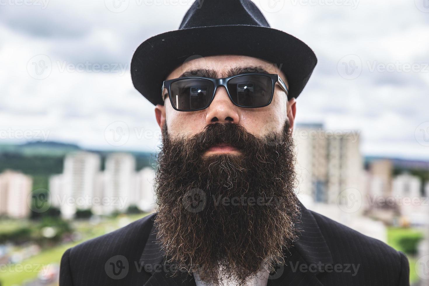 hombre barbudo mirando a la cámara. concepto de masculinidad y cuidado con la barba. señalando con el dedo, aprobando o indicando. foto